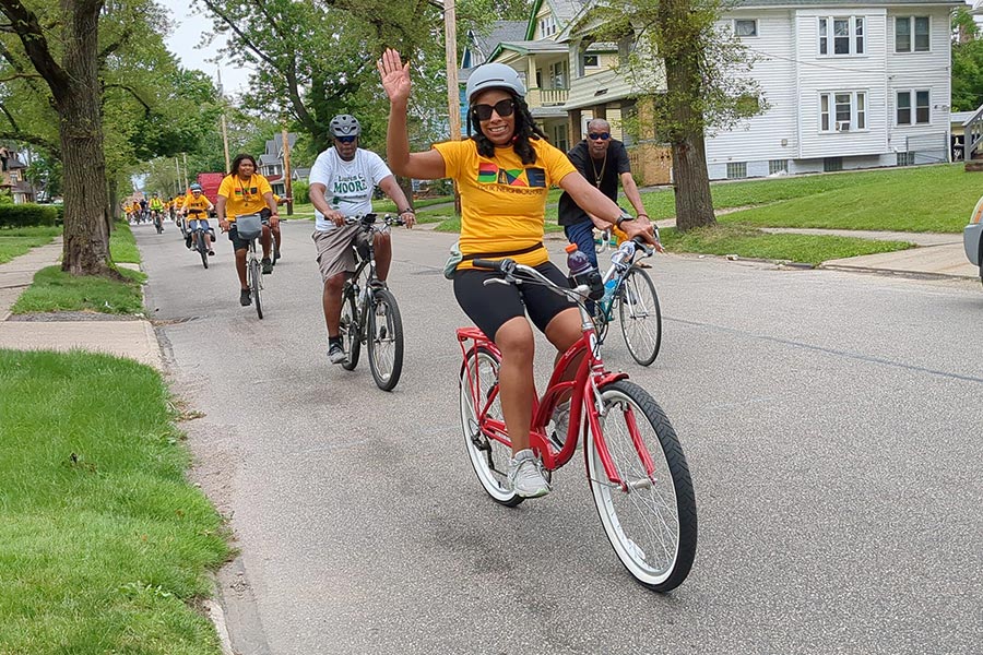 Woman riding bike and waving hello